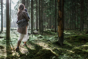 Woman walks through a forest in Estonia